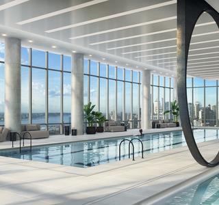 Hudson Yards Aquatics Center: An indoor pool with lounge chairs around it, view of NYC & river.