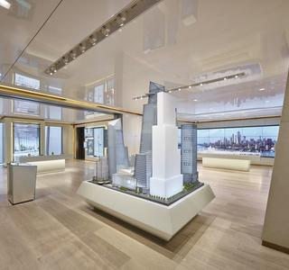 Hudson Yards sales center with a project model in the middle & a view of the city in the distance.